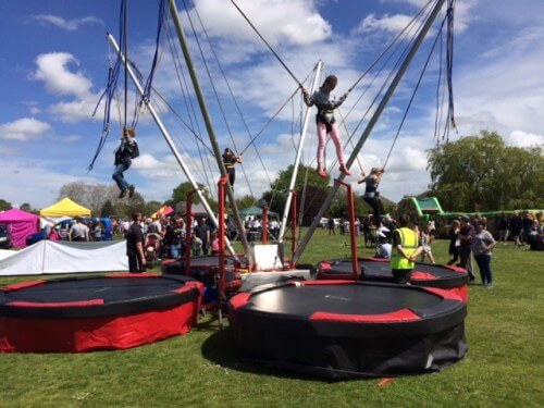 kids enjoying the 4-in-1 bungee trampoline in a fair