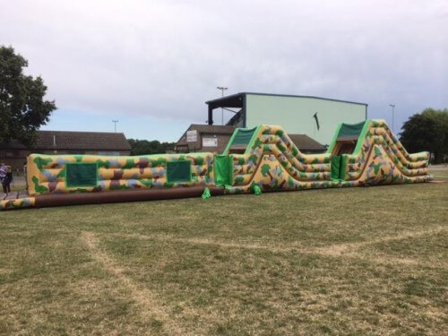 86ft inflatable army assault course in a field